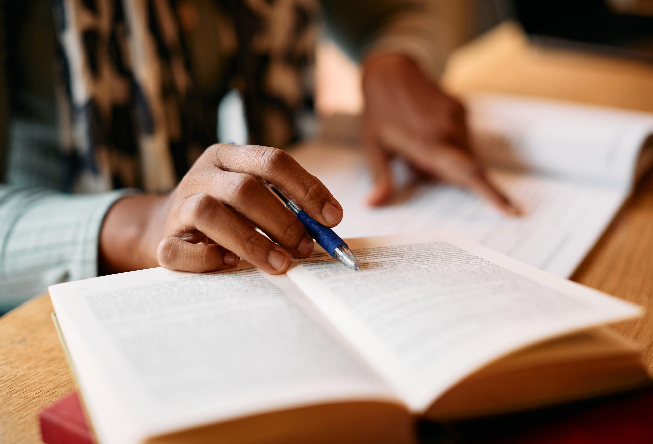 person reading a book and taking notes