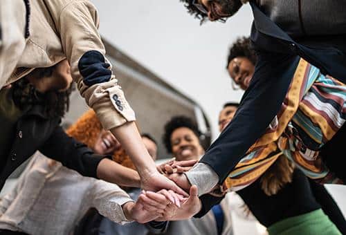 group of people throwing their hands together