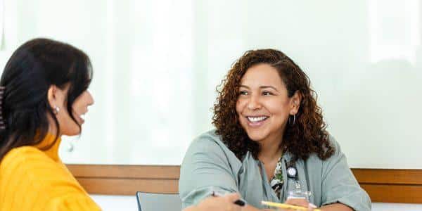 Two women in discussion, casual meeting, smiling