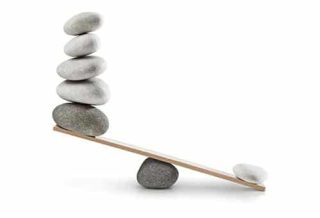 an unbalanced seesaw with stones with the side with five stones lighter than the side with only one stone