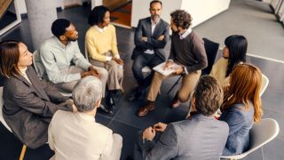 educators sitting in a circle, listening and discussing during a group meeting