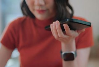 a woman holding a phone and listening to it