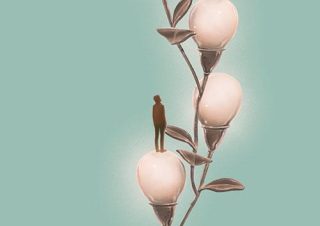 a plant with lighbulbs for flowers and a person standing on one
